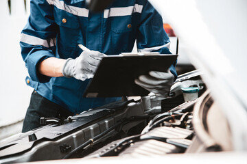Car care maintenance and servicing, Hand technician auto mechanic checking inspection list after fix or repairing change spare part car engine problem and car insurance service support assistance.