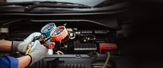 Car care maintenance and service, Hand technician auto mechanic using measuring manifold gauge check refrigerant and filling car air conditioner to fix repairing heat conditioning system.