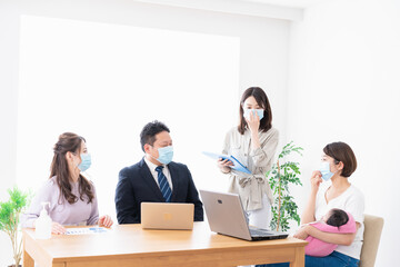 赤ちゃんを連れてオフィスで働く女性