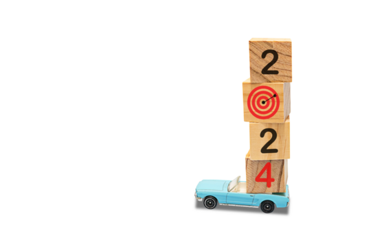 Model car with wooden blocks on top. The concept of traveling towards the goal. Countdown to 2024 with target board on stacked wooden cubes for preparing and starting new business goal strategy ideas.