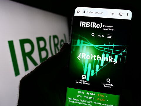 Stuttgart, Germany - 09-11-2023: Person holding cellphone with webpage of Brazilian reinsurance company IRB Brasil RE on screen in front of logo. Focus on center of phone display.