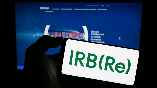 Stuttgart, Germany - 09-11-2023: Person holding smartphone with logo of Brazilian reinsurance company IRB Brasil RE on screen in front of website. Focus on phone display.