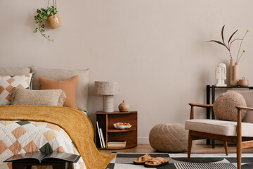 Interior design of warm bedroom with mock up poster frame, black rack, bed with orange bedding,...