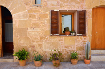 A window of an old Spanish house decorated with flowers and cactuses - Alcúdia, Mallorca