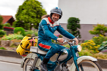 Driving a scooter. Man with vintage helmet rides the scooter. Portrait of a smiling man and with a...