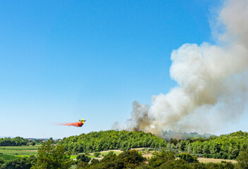 tragic view of forest fire and helibucket which  is a specialized bucket suspended on a cable carried by a helicopter to deliver water for aerial firefighting 