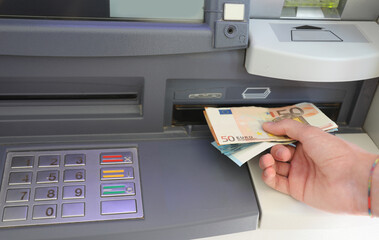 withdrawing euro banknotes in automatic teller machine in Europe