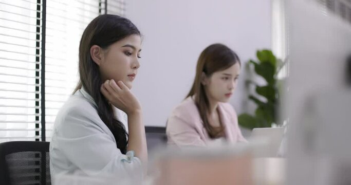 Two Asian business women are sitting and working in the office. Teamwork will make the team successful. Working with data technology is good business planning.