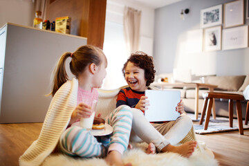 Young caucasian brother and sister using a tablet together at home