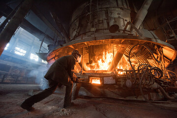 Steelworker at work near the arc furnace - 648182663