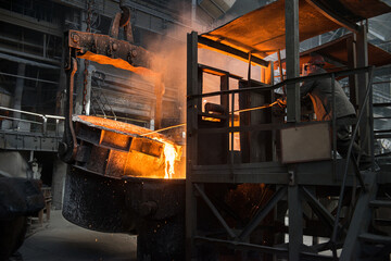 Steelworker at work near the tanks with hot metal - 648182885