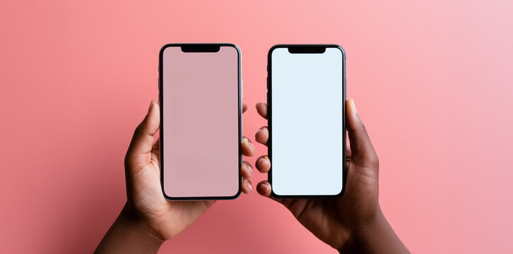 Two iPhones. Isolated on a pink background. White screens. Held in hand. Insert your own screen image. For app mockups.