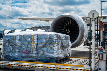 Air cargo logistic containers are loading to an airplane.