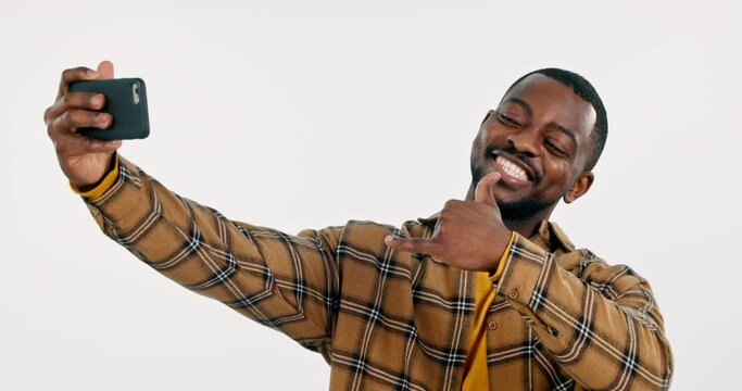 Online, black man or influencer taking a selfie in studio on social media with peace sign. Fashion, smile or cool happy African person taking a photo, vlog or picture isolated on white background