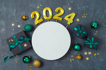 Christmas holiday concept with 2024 new year, decorations, gift boxes and ornaments on dark background. Top view, flat lay