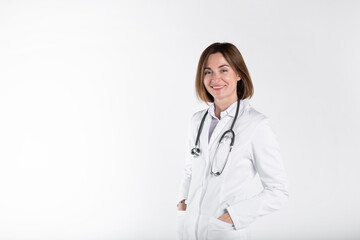 Fototapeta premium Young attractive female doctor standing and smiling isolated on white background 