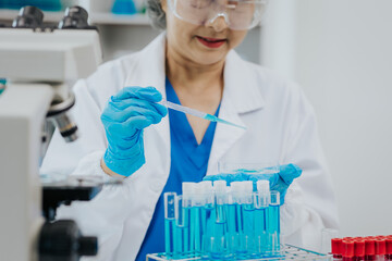 Fototapeta premium Two Asian scientists in the laboratory or medical personnel looking at a microscope in the lab