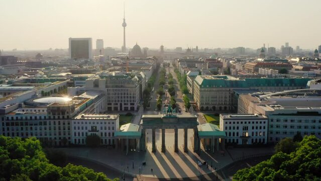 Establishing Aerial view of Berlin Skyline with Brandenburg City Gate. Main touristic landmarks of German capital as Symbolic travel destination. Scenic 4K drone zoom out wide shot
