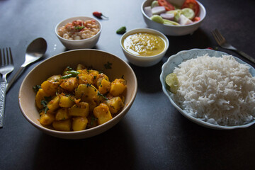 Ready to eat Indian veg meal rice, potato masala, dal and salad. Close up, selective focus.