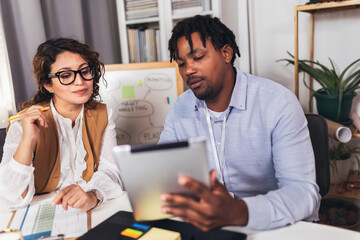 Portrait of young business people working together in home office. Couple teamwork startup concept