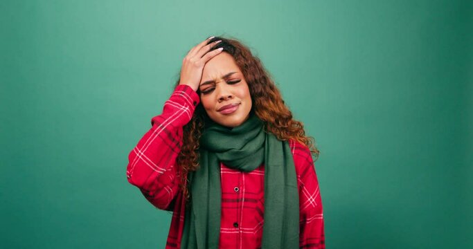 Forgetful young woman hits head with hand in disbelief, duh moment, studio