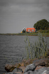 altes Haus am Meer mit orangenem Dach