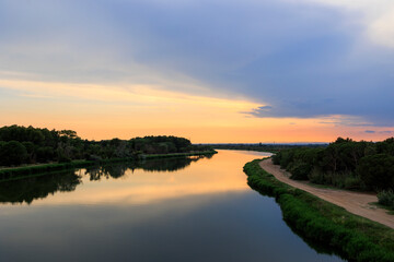Colorful sunset over the water of the Canal du Rhone near Aigues-Mortes in Carmarque