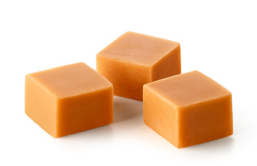 Three caramel candy cubes on white background