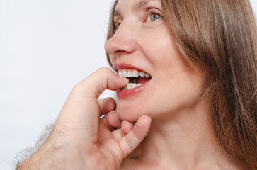 Beautiful woman playfully bites man's finger