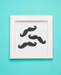 Paper-cut mustache in a frame on a blue background. Father's day concept