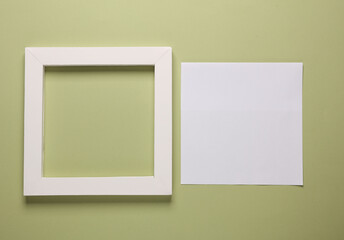 Blank square frame with white sheet of paper on green background