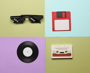 Audio cassettes, pixel glasses and floppy disks on a colored background. Creative layout, retro...