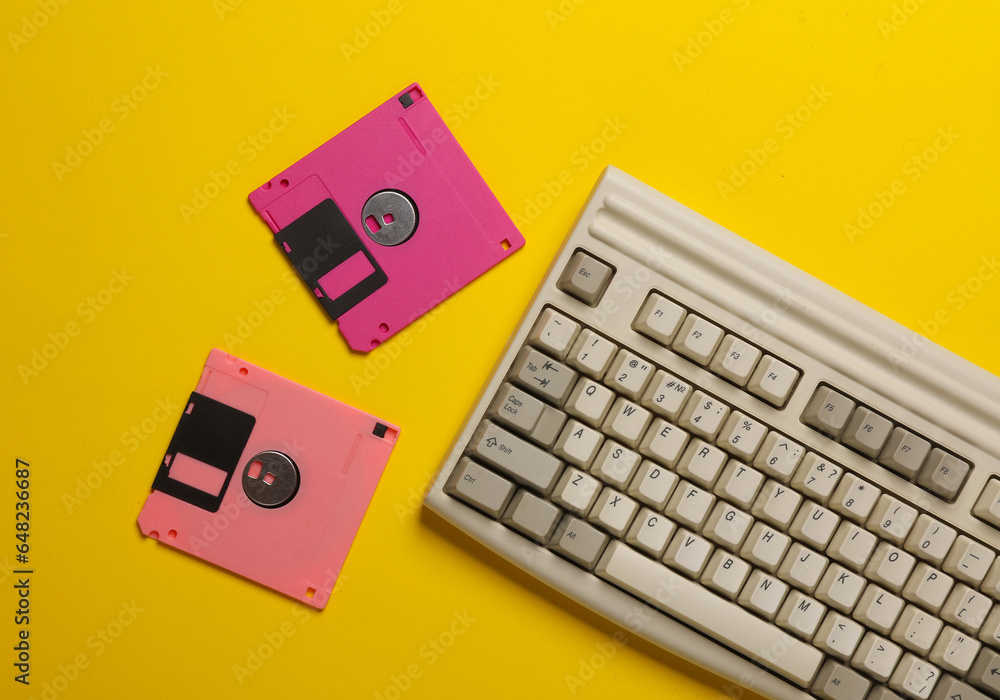 Aufkleber retro keyboard and floppy disks on yellow background. top view