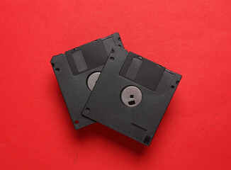 Black floppy disks on a red background. Retro 80s