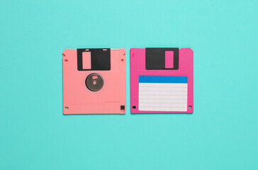 Two pink floppy disks on a blue background. Top view