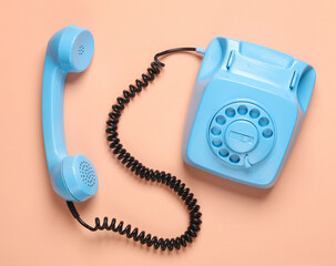Blue retro rotary telephone on a pink background. Minimalism. Top view