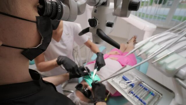 Innovative dental microscope for checkup of patient cavity focused dentist using professional equipment to see teeth of woman in details
