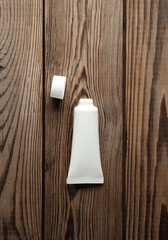 Open White cream tube on wooden background. Creative layout. Template for design. Mockup. Minmal beauty concept.