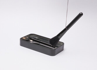 Box with make-up brushes on a gray background