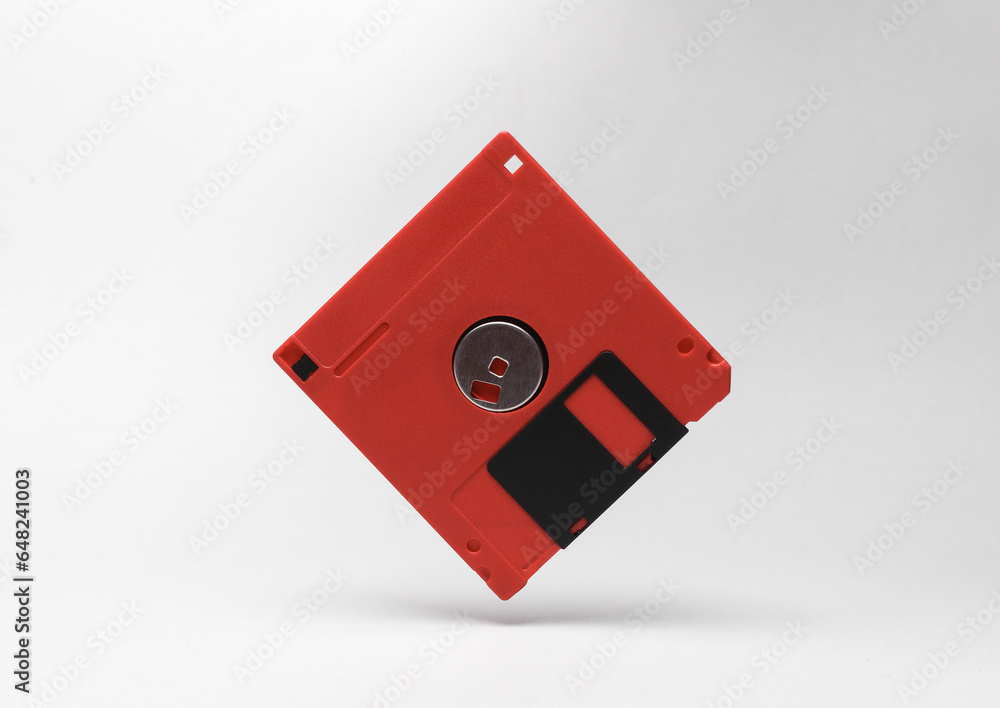 Poster red retro floppy disk levitating on a gray background