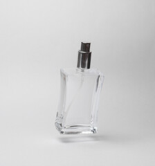 Glass bottle of perfume on a gray background with a shadow. Beauty concept
