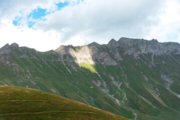 The slopes of the Caucasus mountains are covered with forest and greenery.
