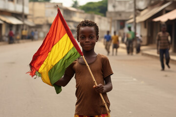 Un garçon guinéen tenant le drapeau de la Guinée dans les rues de Conakry