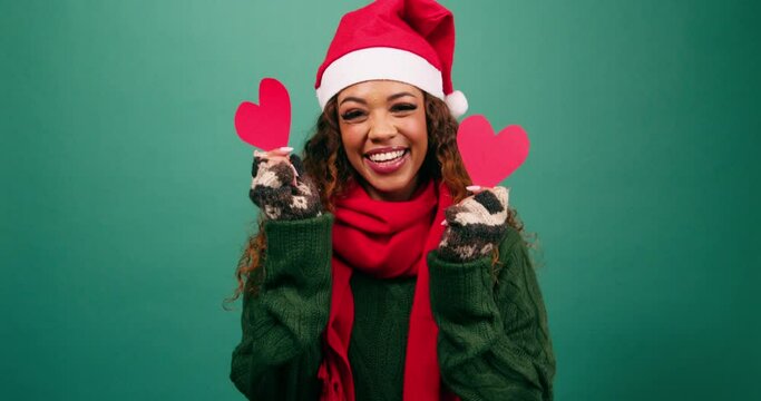 Beautiful young woman covers eyes with heart shapes, love at Christmas time