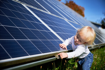 Little boy wondering what solar panel is. Curious child trying to understand how does solar battery...