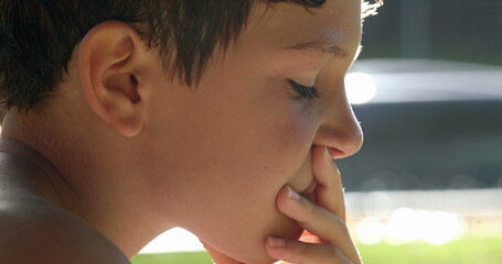 Contemplative child boy pondering solution to decision making. Pensive kid thinking deeply