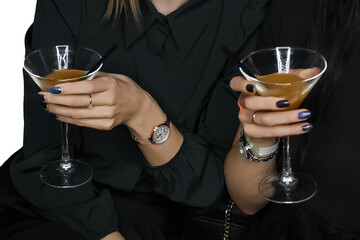 Hands of two girls in black clothes holding glasses with an alcoholic beverage close-up atmosphere of relaxation, close up