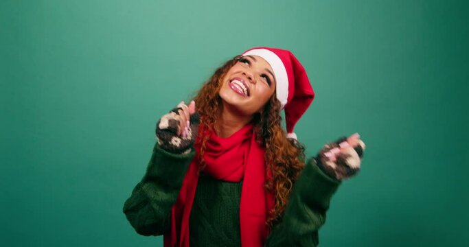 Happy young woman dancing in studio, Christmas theme Santa hat
