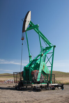 Pumpjack against a blue sky; Longview Alberta Canada