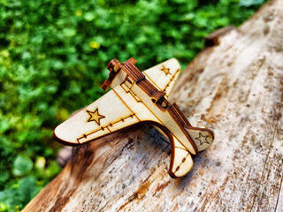 Vintage toy wooden airplane with stars on wing in nature. Plane crash, breakdown. Old Soviet glider...